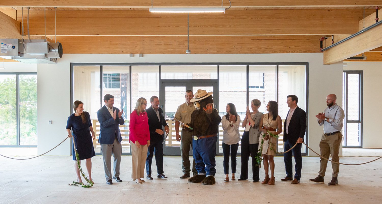 A group of people celebrate the ribbon cutting inside 619 Ponce