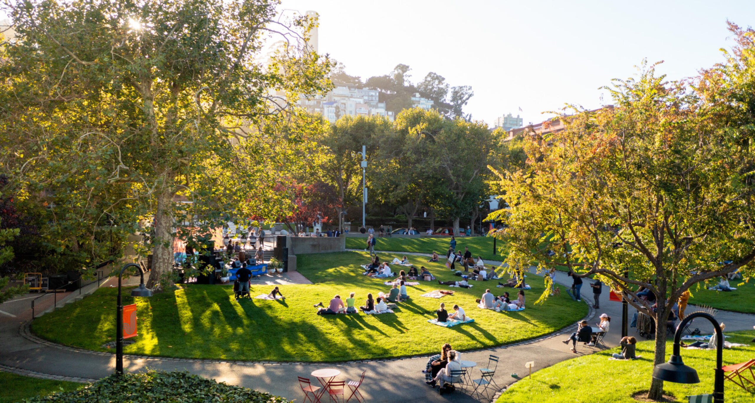 View of greenspace at Levi's Plaza with visitors relaxing on a grassy hill